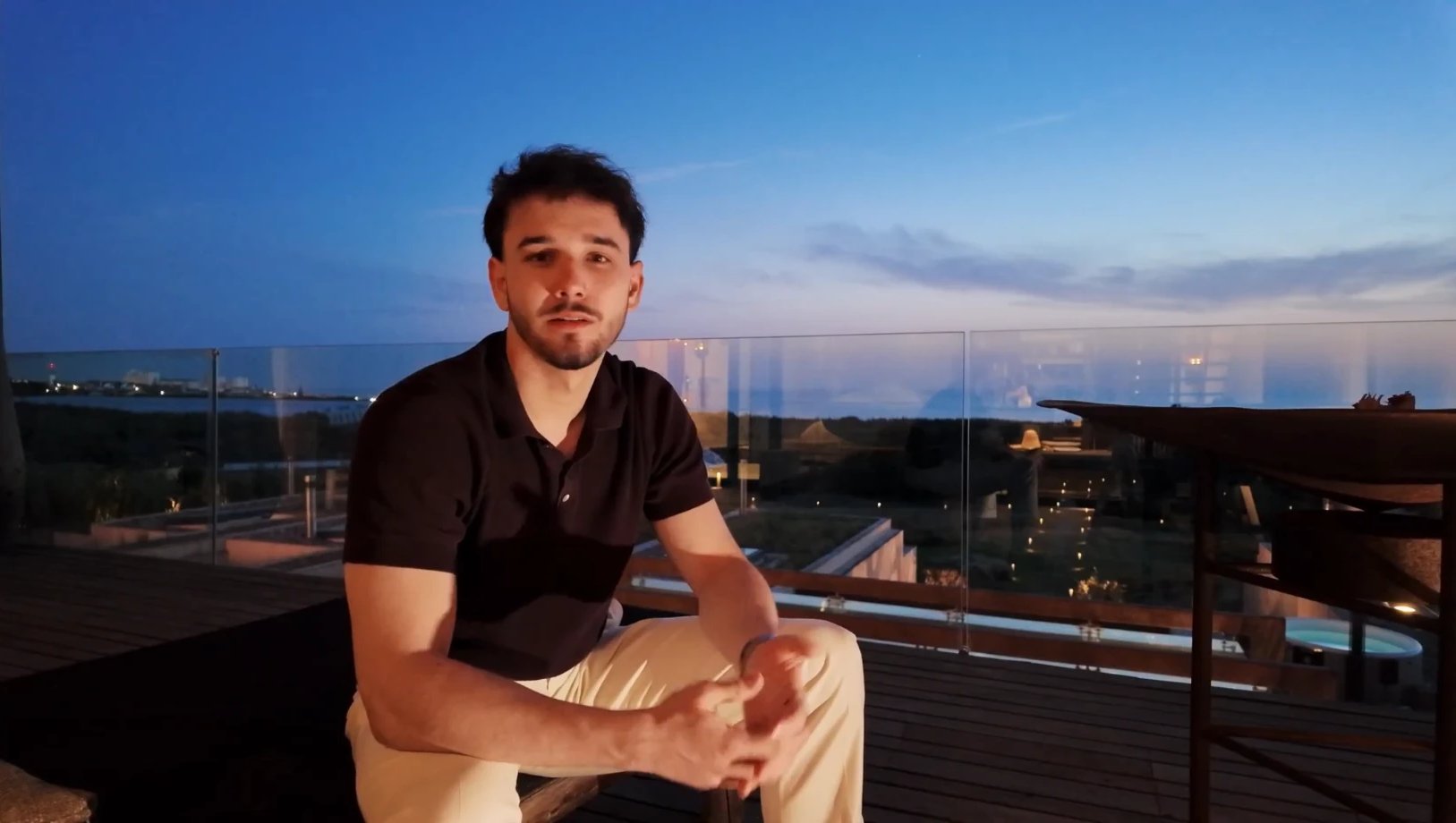 Tinus Klauser sitzt zur blauen Stunde auf einer Dachterrasse und spricht in die Kamera.